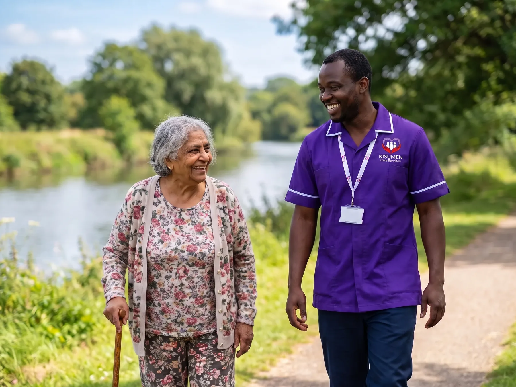 Kisumen carer walking with an older woman along the River Medway as part of local home care